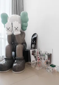 A minimalist room featuring a modern interior design artwork with a pair of large, oversized shoes in grey and teal, alongsid