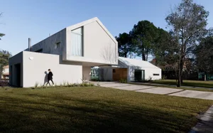 A modern minimalist house with a concrete exterior and large windows.