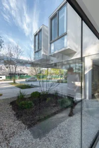 Modern residential exterior featuring glass and concrete materials.