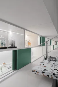 Modern showroom with glass cabinets, marble surfaces, and metallic accents.