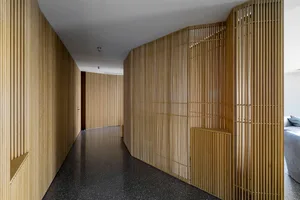 A modern interior design featuring a corridor with wooden slatted walls and black marble floor.