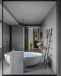 A minimalistic bathroom with a freestanding bathtub made of terrazzo