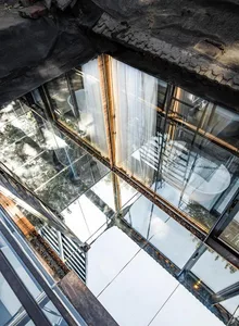 A minimalist interior design with large glass windows and panels.