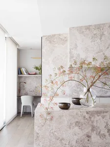 A minimalist living room with a marble accent wall and decorative elements.