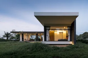 Modern minimalist home with large glass windows and concrete facade