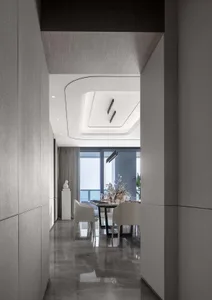 Modern dining room featuring a sleek tile wall and contemporary light fixtures.
