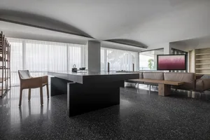 A modern living room featuring minimalist design with concrete and marble elements.