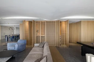 A modern living room featuring wood paneling and minimalist furniture.