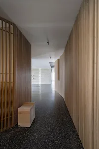 A modern minimalist hallway featuring wooden walls and polished concrete flooring.