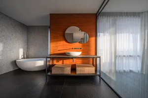 Modern minimalist bathroom featuring a concrete floor, wood accents, and glass elements.