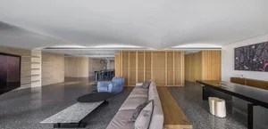 Contemporary living room featuring a sleek gray sofa with marble accents and a wooden partition wall.
