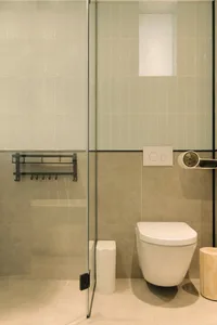 A modern minimalist bathroom with white tiles and a white toilet.