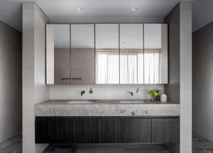 Modern bathroom with marble countertop and wooden cabinets.