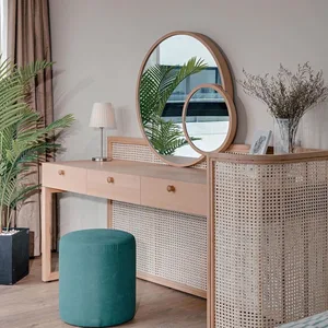 Modern bedroom with a wooden vanity, green stool, and circular mirrors.