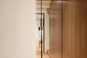 A modern living room with wooden walls and glass doors.