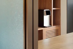 Modern kitchen featuring wooden shelving and a sleek water dispenser.
