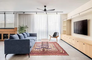Modern living room with blue sofa, coffee table, and large window.