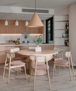 A modern residential kitchen dining area showcasing a wooden table and chairs, with a wooden pendant light hanging above and 