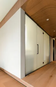 A modern wooden corridor with glass doors and a sleek, minimalist design.