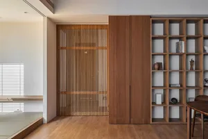 A minimalist interior design featuring a wooden library with wooden slatted walls.