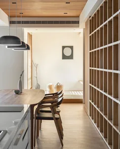 Modern dining room featuring natural wood elements, including chairs and table.