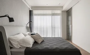A modern bedroom featuring a textured bedspread and minimalist design.