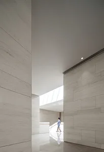 A modern lobby area featuring concrete walls and a high ceiling with a skylight.