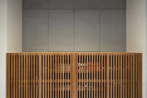 A modern storage cabinet with wood slats and a sleek, minimalist design.