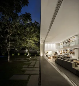A modern minimalist living room featuring concrete flooring and walls.