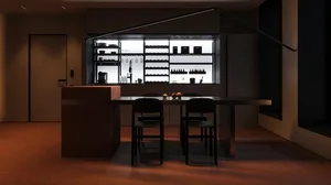 A modern minimalist residential kitchen with metallic cabinets, glass shelves, and wooden dining chairs.