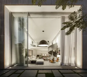 Modern residential interior with glass walls and wooden furniture.