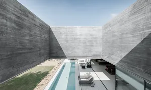 A modern exterior design with concrete walls and a pool.