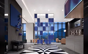Modern hotel lobby featuring glass partitions and metal chairs
