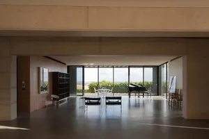 A modern living room with concrete flooring and walls, featuring large windows and minimalist furniture.