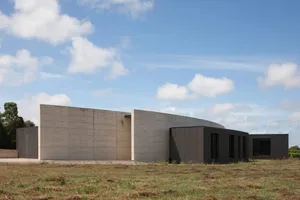 A modern, minimalist residential house featuring concrete exteriors.