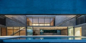A modern minimalist house with a concrete and glass exterior.