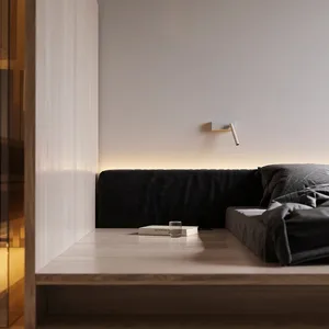 Black textured sofa in a minimalist space with ambient lighting and a simple wooden platform.