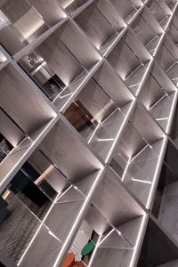 A contemporary bookshelf with wooden shelves and LED lighting.