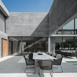 A contemporary patio featuring modern furniture on a concrete surface.