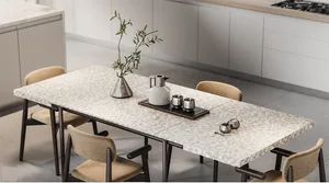 Modern dining room featuring a terrazzo table with a vase of greenery, a kettle, and salt and pepper shakers on a wooden tabl