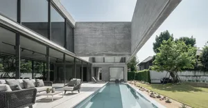 Modern minimalist house with concrete exterior and swimming pool.