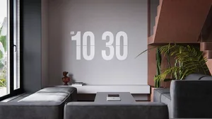 A modern minimalist living room with a concrete wall displaying the time '10:30 AM'.