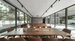 Contemporary dining room with concrete, glass, and leather materials and a large table.