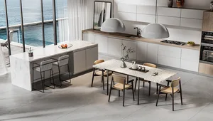 Modern kitchen with marble countertops, white cabinets, and a dining table with beige chairs.
