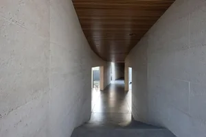 Long corridor with concrete walls and wooden ceiling