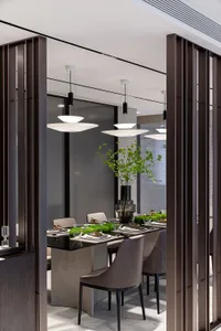 Modern dining room interior with sleek, minimalist design featuring metal and glass furniture.