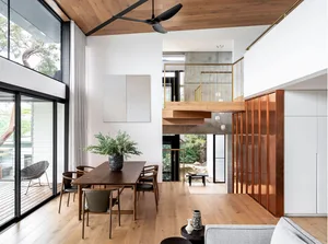 A modern dining room featuring wooden furnishings and a large window