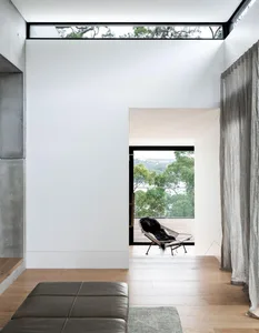 Modern living room with wooden floors, concrete walls, and textiles.