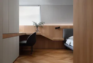 簡約臥室，搭配木質床頭板與嵌入式書桌區。