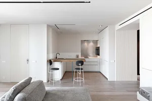 Modern minimalist kitchen with a wooden countertop and white appliances.